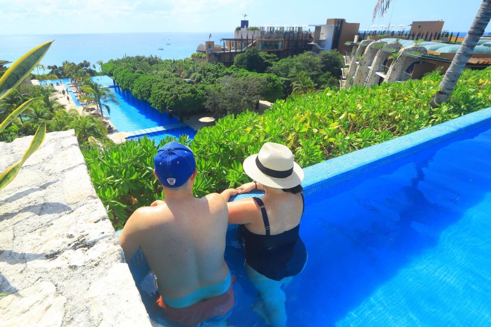 Author Sara Iannacone and her husband facing the skyline in a rooftop pool