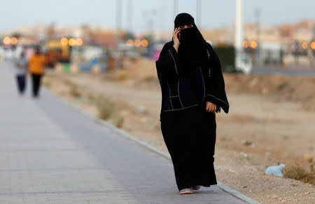 A Saudi woman speaks on a phone as she walks on a sidewalk in Riyadh, Saudi Arabia September 21, 2017. REUTERS/Faisal Al Nasser