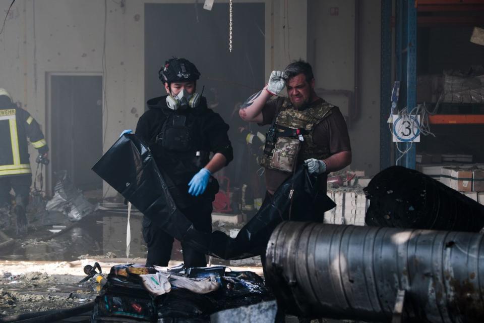 First responders work at the site of a Russian missile attack on a publishing factory in Kharkiv, Ukraine on May 23, 2024. (Francis Farrell/The Kyiv Independent)