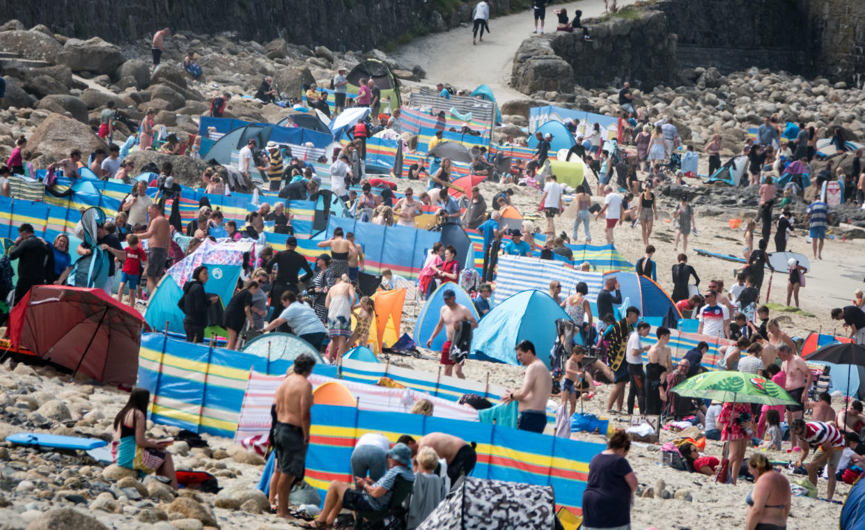 SENNEN COVE, ENGLAND - AUGUST 01: Crowds of people gather on the beach at Sennen Cove on August 1, 2021 in Cornwall, England. With international travel restrictions remaining likely for this summer at least, many parts of the UK are set to be very popular with holidaymakers opting to have domestic holiday or a so called staycation within the UK. (Photo by Matt Cardy/Getty Images)