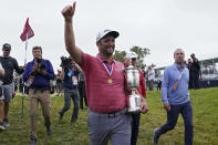 Jon Rahm, of Spain, leaves the 18th green with the champions trophy after the final round of the U.S. Open Golf Championship, Sunday, June 20, 2021, at Torrey Pines Golf Course in San Diego. (AP Photo/Marcio Jose Sanchez)