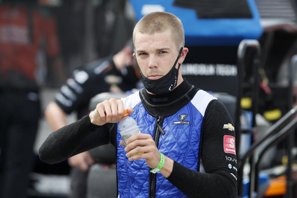 FILE- In this July 18, 2020, file photo, Oliver Askew stands in the pit area during practice for an IndyCar Series auto race, at Iowa Speedway in Newton, Iowa. The IndyCar rookie will not compete in next week's doubleheader at Indianapolis because of concussion-like symptoms that date to his crash in the Indianapolis 500 last month. (AP Photo/Charlie Neibergall, File)