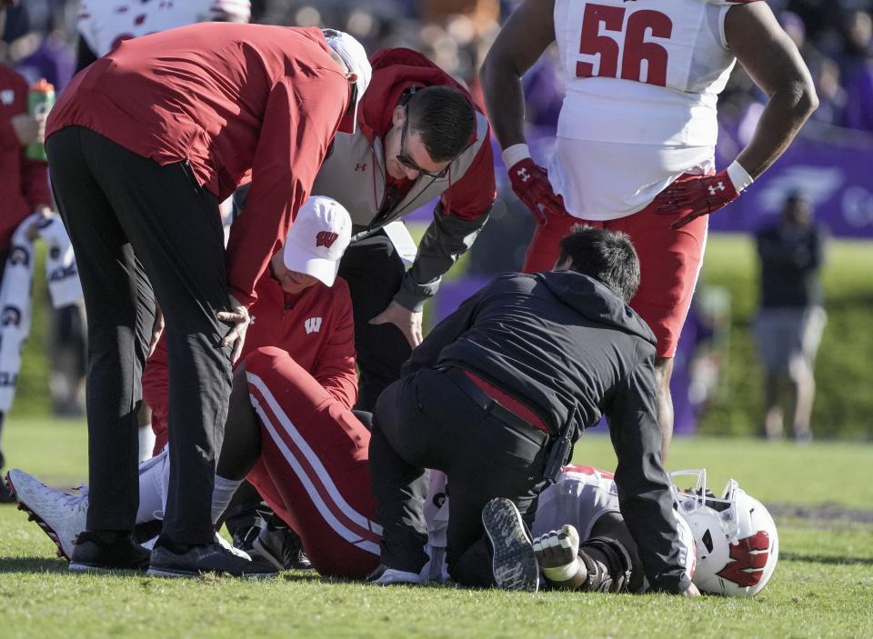 Wisconsin Badgers nose tackle Keeanu Benton (95) is tended to during the game against the Northwestern Wildcats Saturday, Oct. 8, 2022, at Ryan Field in Evanston, Illinois.