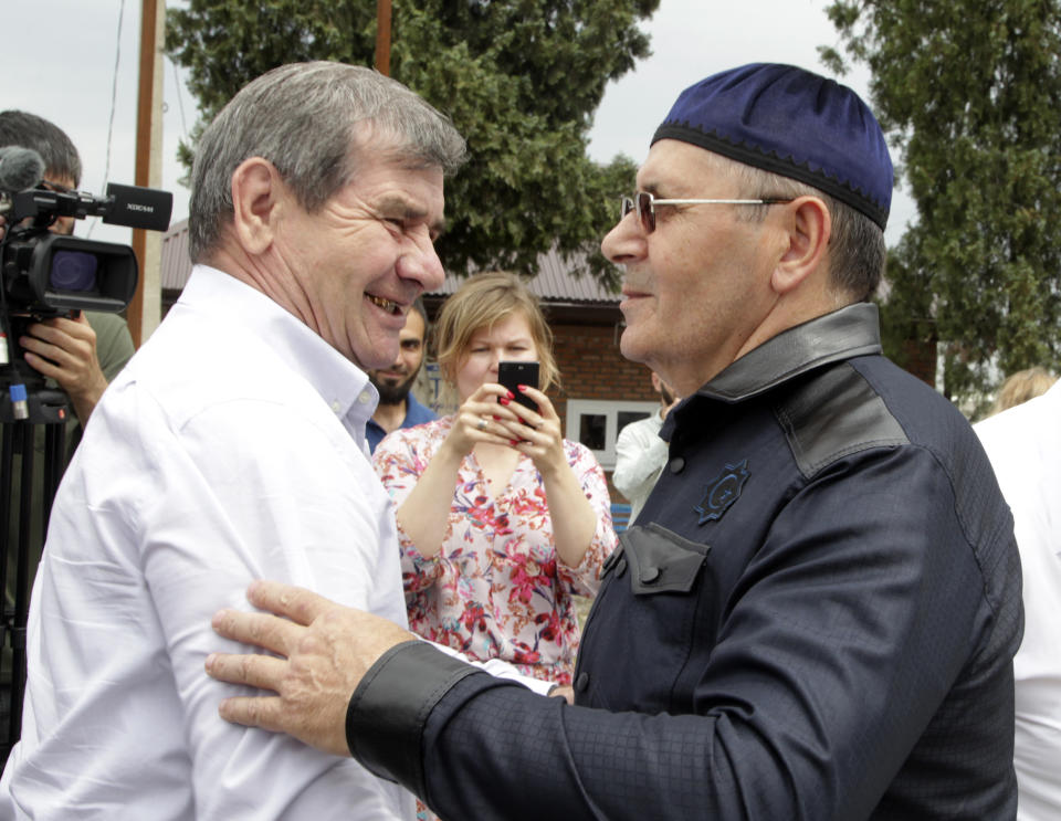 Oyub Titiev, the head of a Chechnya branch of the prominent human rights group Memorial, right, is greeted by a friend as he leaves a prison in Argun, Russia, Friday, June 21, 2019. Titiyev was released from a Russian prison on Friday morning, more than 18 months after first being detained on drug charges his supporters say were fabricated. (AP Photo/Musa Sadulayev)