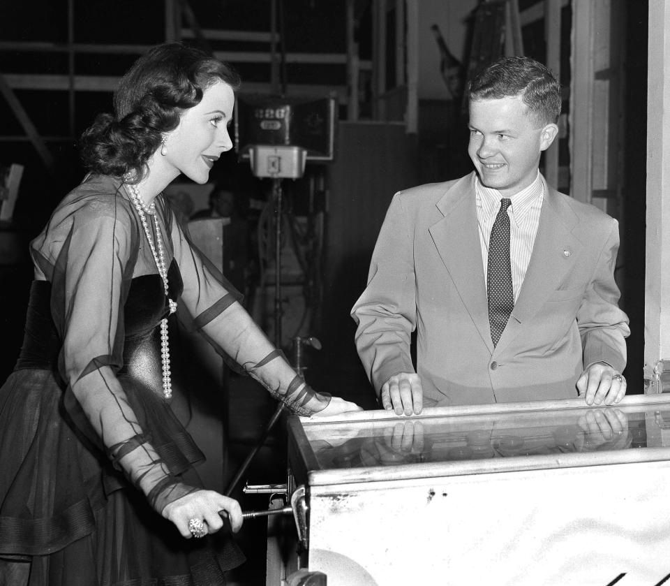 FILE - In this 1945 file photo, actress Hedy Lamarr shoots pinball accompanied by Associated Press reporter Bob Thomas. Thomas, the longtime Associated Press reporter who kept the world informed on the comings and goings of Hollywood's biggest stars, died of age-related illnesses Friday, March 14, 2014 at his Encino, Calif., home, his daughter Janet Thomas said. He was 92. (AP Photo)