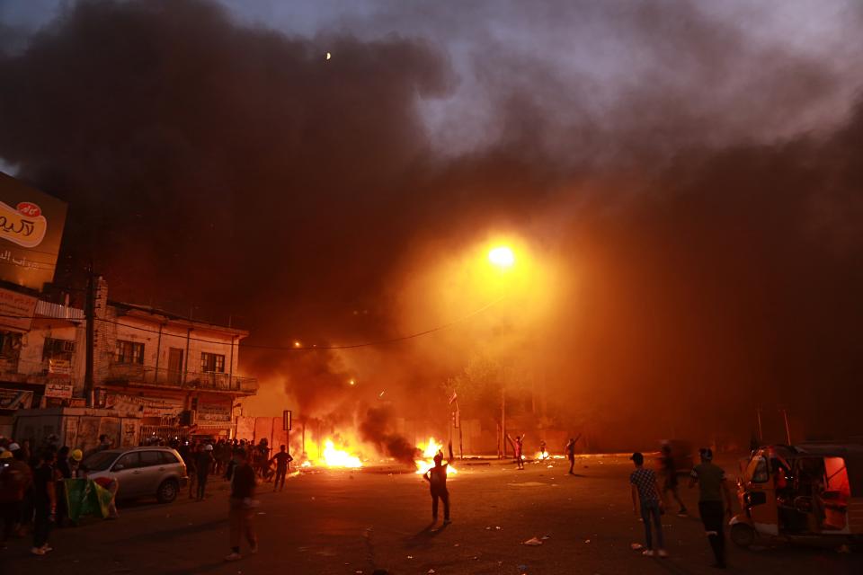 Anti-government protests set fire while security forces fired live ammunition and tear gas near the state-run TV in Baghdad, Iraq, Monday, Nov. 4, 2019. (AP Photo/Khalid Mohammed)