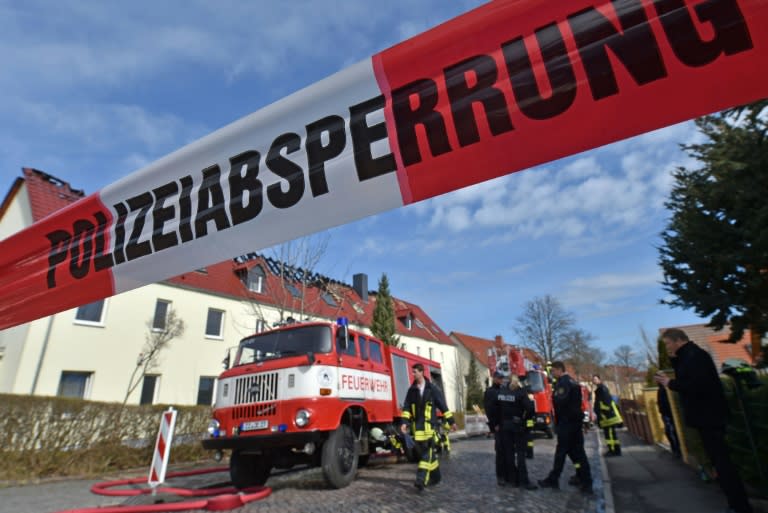 Members of the fire brigade work at the scene of a fire at a house planned to host asylum seekers, in the small town of Troeglitz on April 4, 2015