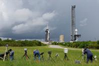 Photographers set up remote cameras as a SpaceX Falcon 9 rocket is prepared for another launch attempt for Polaris Dawn, a private human spaceflight mission