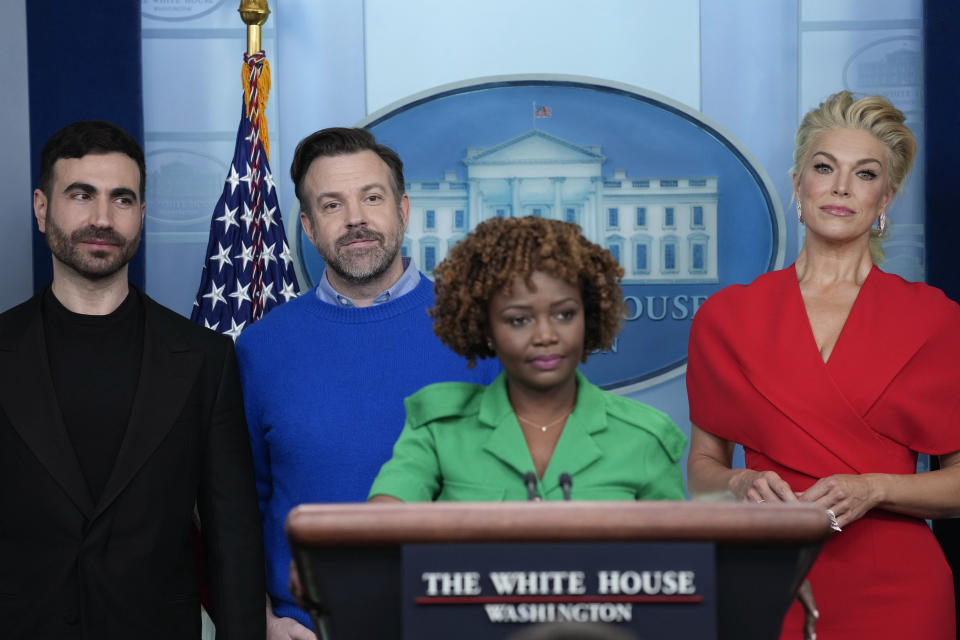 Jason Sudeikis, second from left, who plays the title character in the Apple TV+ series “Ted Lasso”, and fellow cast members Brett Goldstein, left, and Hannah Waddingham, right, join White House press secretary Karine Jean-Pierre, third from left, during the daily press briefing at the White House in Washington, Monday, March 20, 2023. (AP Photo/Susan Walsh)