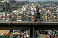 Un homme marche sur un pont routier à Lagos au Nigeria.