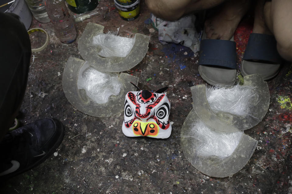 A miniature Lion head waits to be finished as members of a Dragon and Lion dance group seek other ways to earn a living at a creekside house in Manila's Chinatown, Binondo, Philippines on Feb. 3, 2021. The Dragon and Lion dancers won't be performing this year after the Manila city government banned the dragon dance, street parties, stage shows or any other similar activities during celebrations for Chinese New Year due to COVID-19 restrictions leaving several businesses without income as the country grapples to start vaccination this month. (AP Photo/Aaron Favila)