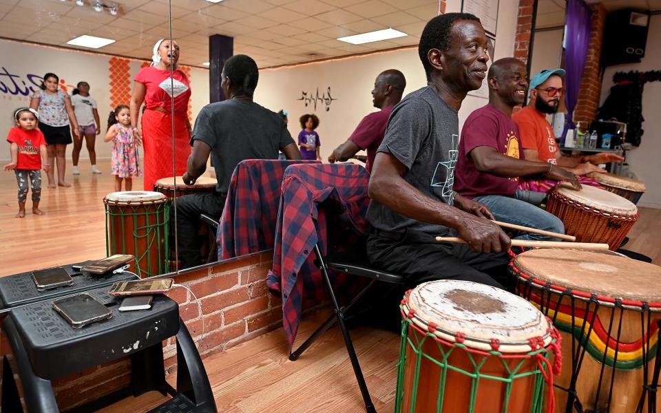 Abou Sylla, Issa Coulibaly and Marino Fernandes, musicians from Worcester-based Crocodile River Muisc, play drums as Lila Sylla teaches students at Ritmos Dance Studio the West African dance, dansa, during a summer workshop Wednesday evening.