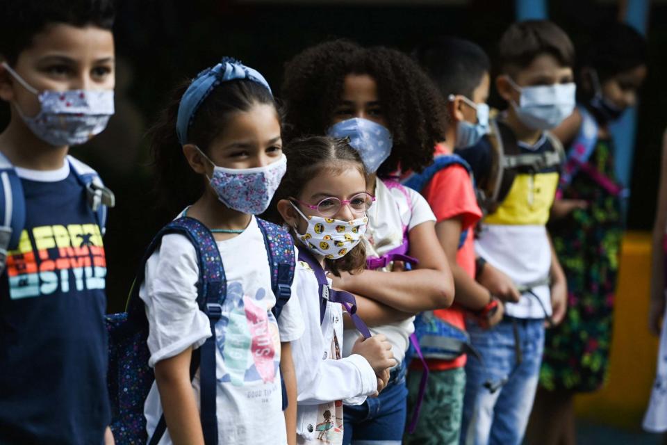 Children line up in face masks (AFP via Getty Images)
