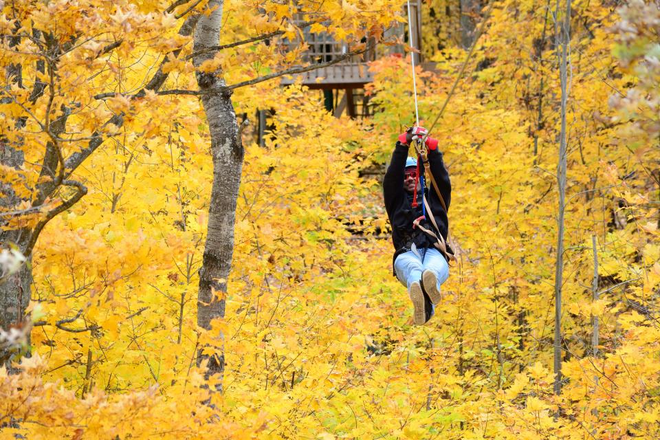 Fall colors surround a zipliner at Wildman Adventure Resort in Niagara.