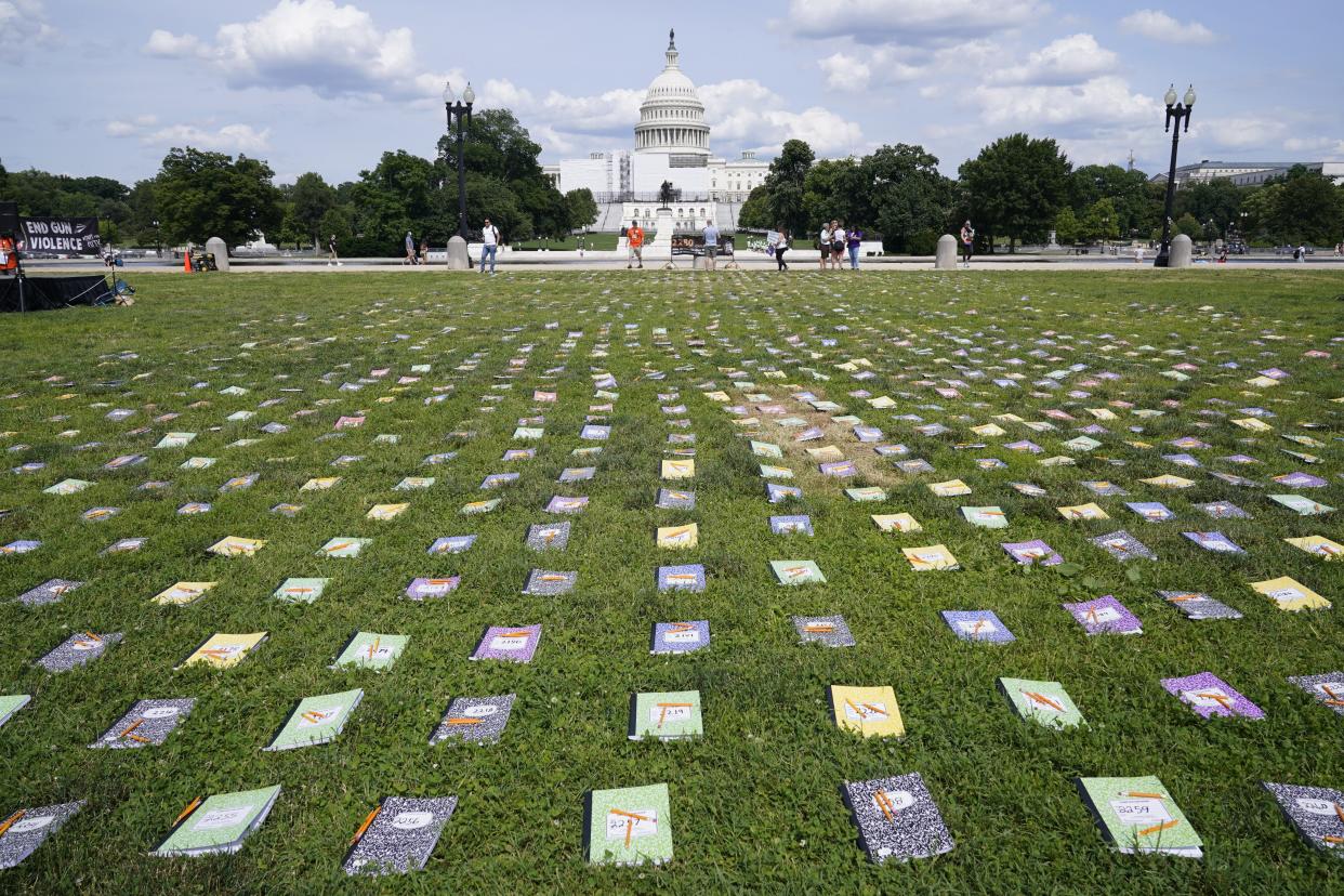 Laid out near the U.S. Capitol are 2,280 schoolbooks and broken pencils that represent children killed by gun violence, during a rally in Washington on Friday, June 10, 2022.