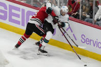 San Jose Sharks left wing Rudolfs Balcers, right, chases the puck past Chicago Blackhawks center Jonathan Toews during the first period of an NHL hockey game in Chicago, Sunday, Nov. 28, 2021. (AP Photo/Nam Y. Huh)