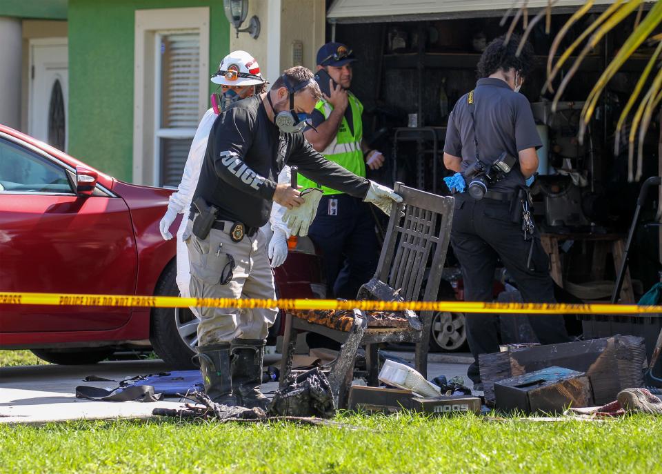 A Port St. Lucie Police Investigator turns to a chair when looking for clues at the scene of a structure fire at a home in the 2600 block of Cactus Circle on Monday, May 1, 2023, in Port St. Lucie. St. Lucie County Fire District investigators search through the remains of the fire in the garage, where a 56-year-old man was found dead.