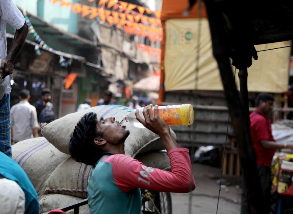An Indian labourer drinks water during hot midday sun at Burabazar in Kolkata, eastern India (EPA)