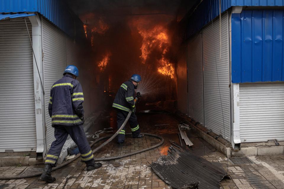 Firefighters tackle a fire at the Slovyansk central market after shelling on Tuesday (Reuters)