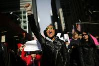 A woman protests in New York City where hundreds of thousands marched in protest of Donald Trump, one year after his inauguration