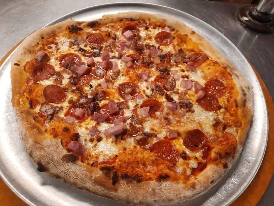 Sixpence Kitchen in Sylvania, Ga., offers pizzas like this "Mighty Meat" pie hand-made in a wood fire.