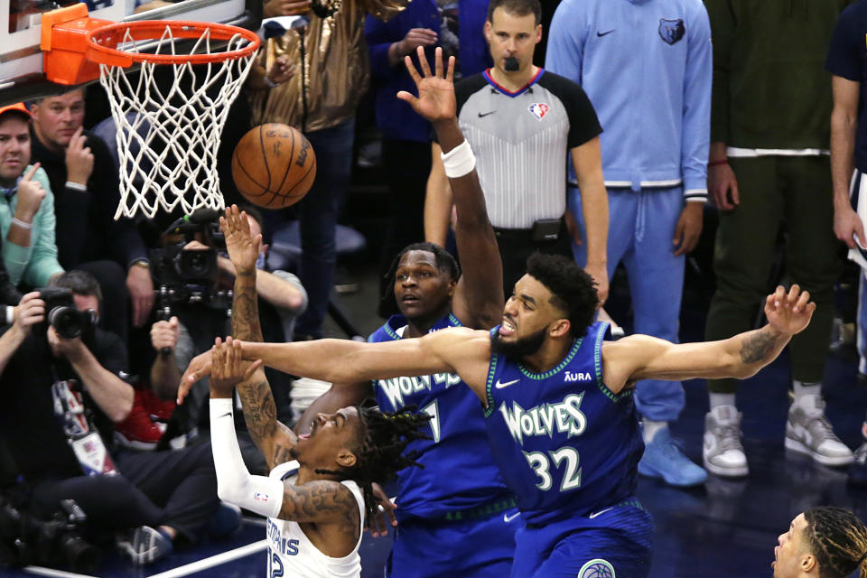 Memphis Grizzlies guard Ja Morant, lower left, shoots in front of Minnesota Timberwolves center Karl-Anthony Towns (32) and forward Anthony Edwards (1) during the second half in Game 6 of an NBA basketball first-round playoff series Friday, April 29, 2022, in Minneapolis. (AP Photo/Andy Clayton-King)