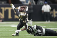 New Orleans Saints running back Alvin Kamara (41) is upended by Jacksonville Jaguars cornerback Darious Williams in the first half of an NFL football game in New Orleans, Thursday, Oct. 19, 2023. (AP Photo/Gerald Herbert)