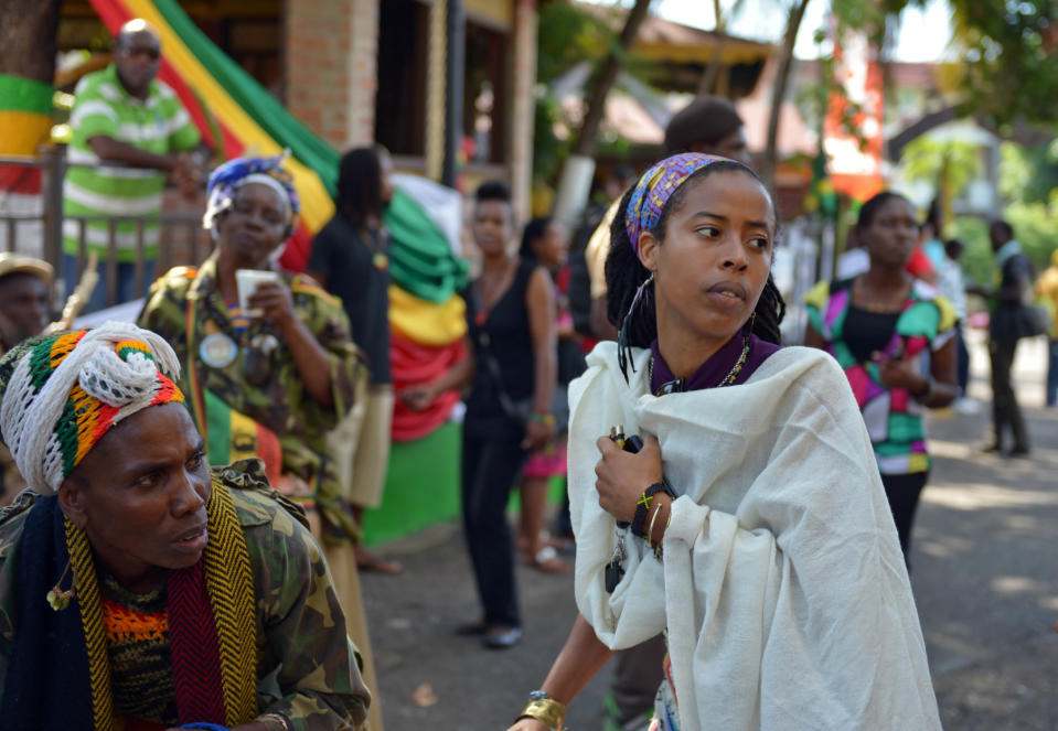 ** CORRECTS STYLE OF MUSIC IN FIRST SENTENCE** Bob Marley’s granddaughter Donisha Prendergast, right, dances to the sound of a Rastafarian drum, during the celebration of Marley's 68th birthday in the yard of his Kingston home, in Jamaica, Wednesday, Feb. 6, 2013. Marley's relatives and old friends were joined by hundreds of tourists to dance and chant to the pounding of drums to honor the late reggae icon who died of cancer in 1981 at age 36. (AP Photo/ David McFadden)