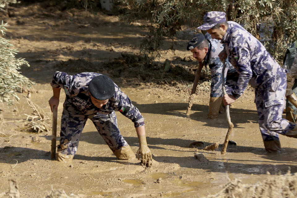 Jordanian rescue teams search Saturday, Nov. 10, 2018 for missing people in the Madaba area, south of the capital of Amman, after flash floods unleashed by heavy rain a day earlier killed several people. (AP Photo/Raad Adayleh)
