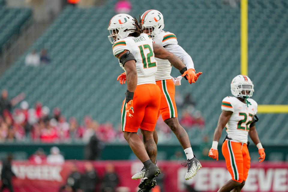Miami Hurricanes defensive lineman Jahfari Harvey (12) celebrates his fumble recovery with linebacker K.J. Cloyd (23) last weekend against the Temple Owls at Lincoln Financial Field in Philadelphia.