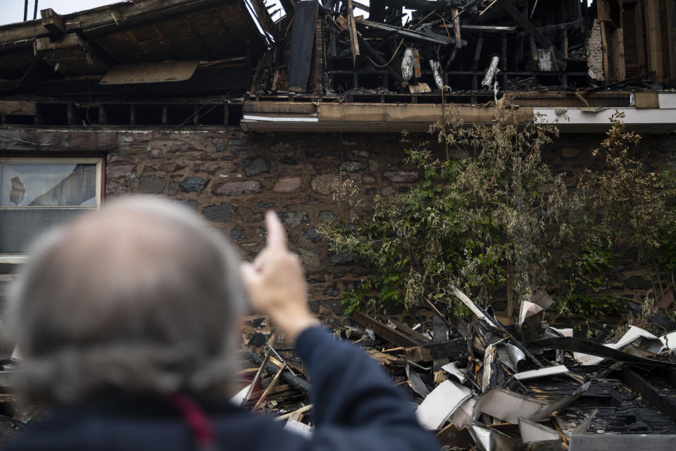 Sam Pomush, whose grandfather helped found the synagogue takes a walk around the building Sunday September 15, 2019 in Duluth, Minn. He points out what he believes to be his grandfathers burnt scroll on the far left. The fire that destroyed the historic synagogue doesn't appear to have been a hate crime, authorities said Sunday in discussing the arrest of a suspect. (Alex Kormann/Star Tribune via AP)