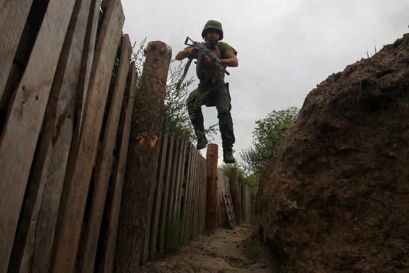 FOTO DE ARCHIVO. Un miembro de la Guardia Nacional ucraniana salta a una trinchera en una posición cercana a la línea del frente, mientras continúa el ataque de Rusia a Ucrania, en la región de Járkov, Ucrania