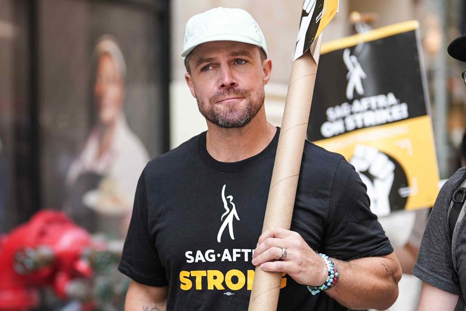 <p>John Nacion/Getty</p> Stephen Amell on the picket lines in New York City