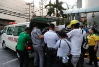 Security and health workers carry a woman employee to an ambulance after she became dizzy as an earthquake hit Manila, Philippines Monday, April 22, 2019. A strong earthquake has shaken the area around the Philippine capital, prompting thousands of people to flee to safety. There were no immediate reports of injuries or widespread damage. The U.S. Geological Survey says the magnitude 6.3 quake struck northwest of Manila, Monday, centered near the town of Gutad on Luzon island. (AP Photo/Aaron Favila)