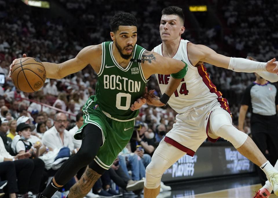 Boston Celtics forward Jayson Tatum (0) dribbles the ball as Miami Heat guard Tyler Herro (14) defends during the first half of Game 2 of the NBA basketball Eastern Conference finals playoff series, Thursday, May 19, 2022, in Miami. (AP Photo/Lynne Sladky)