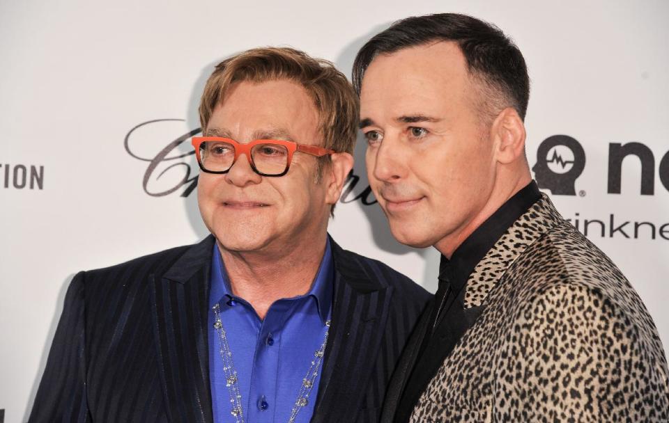 Elton John, left, and David Furnish arrive at the 2014 Elton John Oscar Viewing and After Party on Sunday, March 2, 2014, in West Hollywood, Calif. (Photo by Richard Shotwell/Invision/AP)