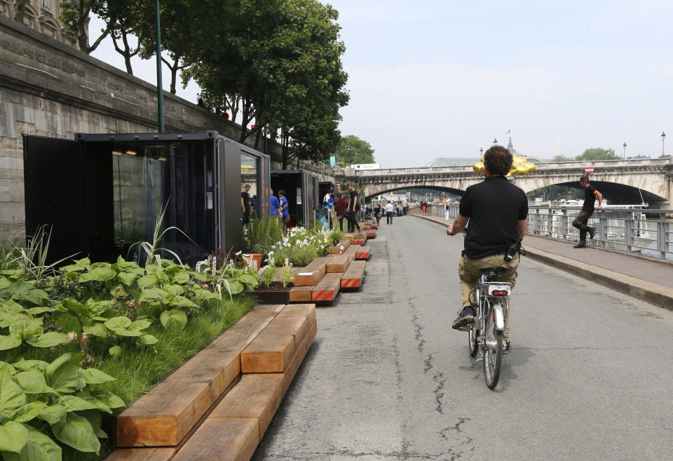 A man rides his bicycle along the renovated Left Bank of the River Seine in Paris where a new promenade has been inaugurated, Wednesday, June 19, 2013 . The 2.3 km (1.4 miles) walkway offers gardens, cafes, culture and sports activities. (AP Photo/Jacques Brinon)