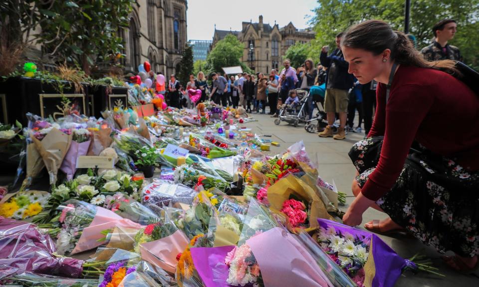 People lay flowers outside the town hall in Albert Square, Manchester.