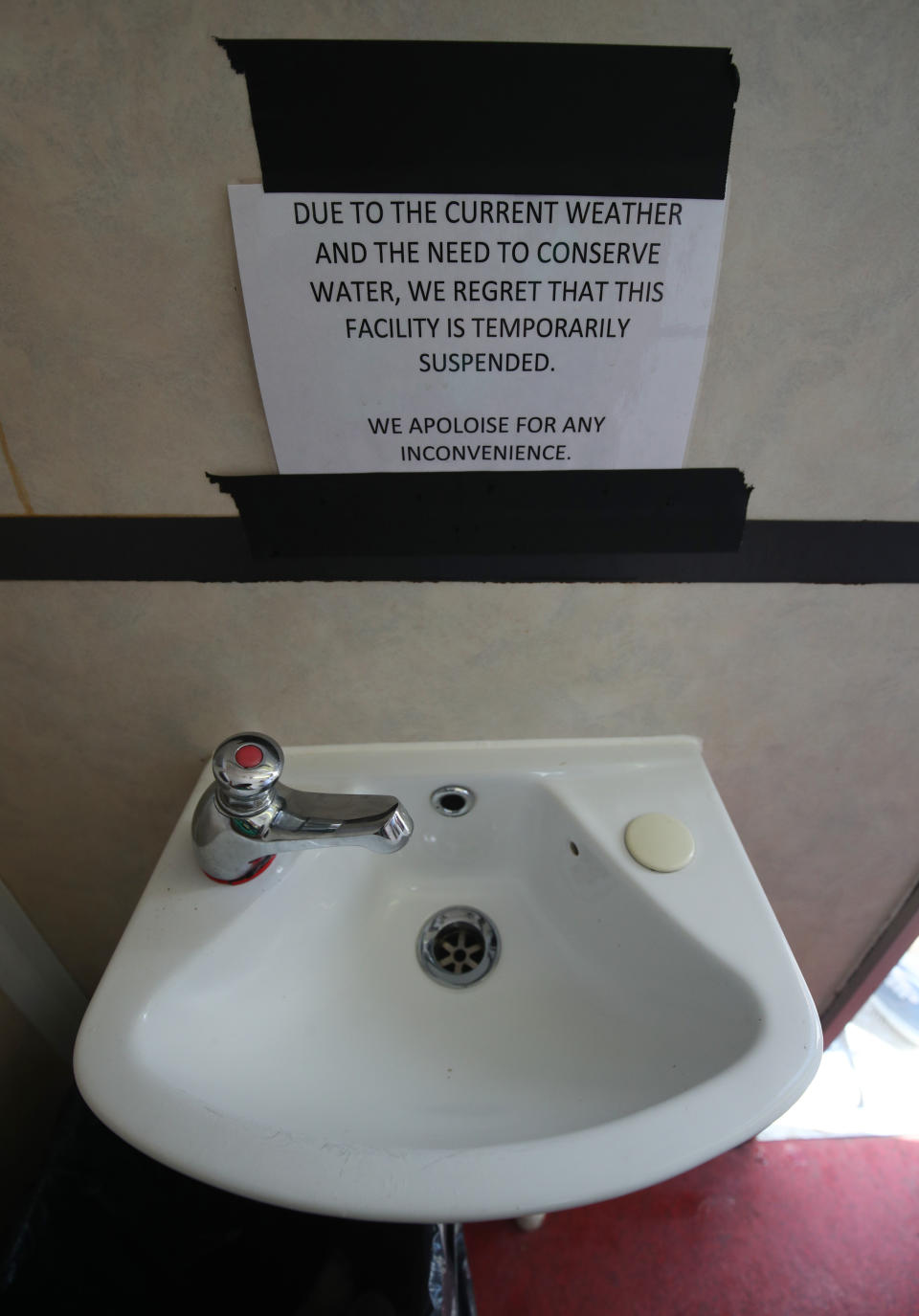 A water suspension notice next to a basin in toilets at the Glastonbury Festival, in Worthy Farm in Pilton, Somerset.