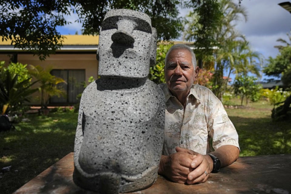 Carlos Edmunds posa para un retrato con una réplica de una estatua moai afuera de su casa en Hanga Roa en Rapa Nui, o Isla de Pascua, el lunes 21 de noviembre de 2022. El consejo de ancianos de Rapa Nui, encabezado por Edmunds, reúne a los líderes cuyos antecesores nacieron en tribus rapanui. (AP Foto/Esteban Felix)