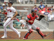 Atlanta Braves' Matt Olson, left, scores as Washington Nationals catcher Keibert Ruiz waits for the ball in the third inning of a baseball game, Sunday, July 10, 2022, in Atlanta. Olson scored on a sacrifice fly hit by Braves' Eddie Rosario. (AP Photo/Ben Margot)