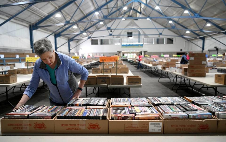 Mary Ann Blair organizes boxes of DVDs that will be for sale at the AAUW Used Book Sale at the Penn State Snider Agriculture Arena on Thursday, May 11, 2023.