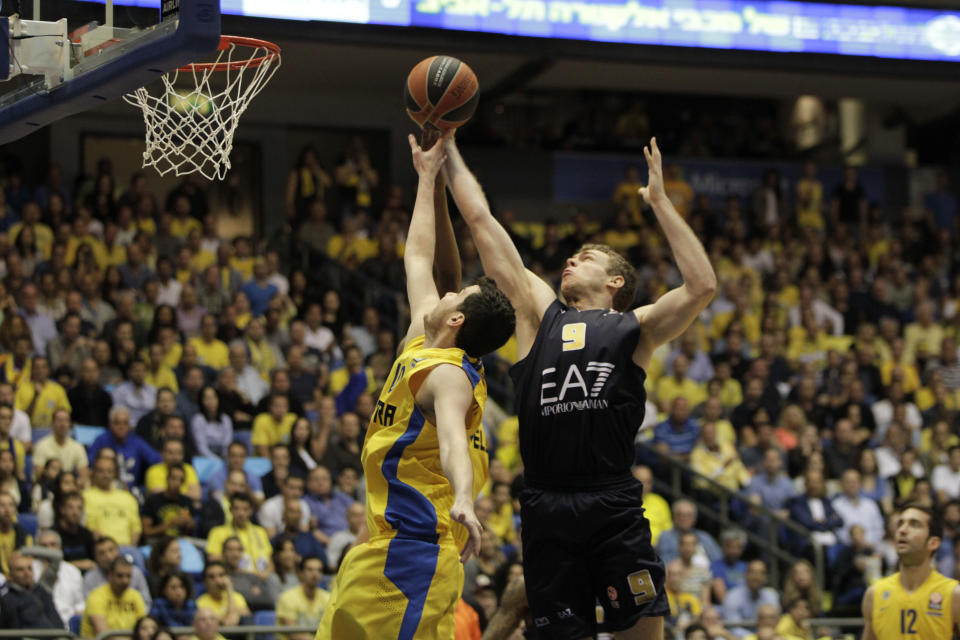 Emporio Armani Milan's Nicolo Melli, right, and Maccbi Tel Aviv's Guy Pnini in action during the EuroLeague Basketball Group D playoffs game in Tel Aviv, Israel, Monday April 21, 2014. (AP Photo/Ariel Schalit)