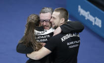 <p>Russian athletes Anastasia Bryzgalova, left, and Aleksandr Krushelnitckii, right, embrace their coach Vasily Gudin after winning the mixed doubles bronze medal curling match against Norway’s Kristin Skaslien and Magnus Nedregotten at the 2018 Winter Olympics in Gangneung, South Korea, Tuesday, Feb. 13, 2018. (AP Photo/Natacha Pisarenko) </p>