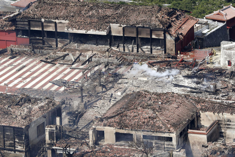 This aerial view shows the burnt-down main temple, center right, and north temple, background, of Shuri Castle in Naha, Okinawa, southern Japan, Thursday, Oct. 31, 2019. A fire early Thursday burned down structures at Shuri Castle on Japan's southern island of Okinawa, nearly destroying the UNESCO World Heritage site. (Kyodo News via AP)