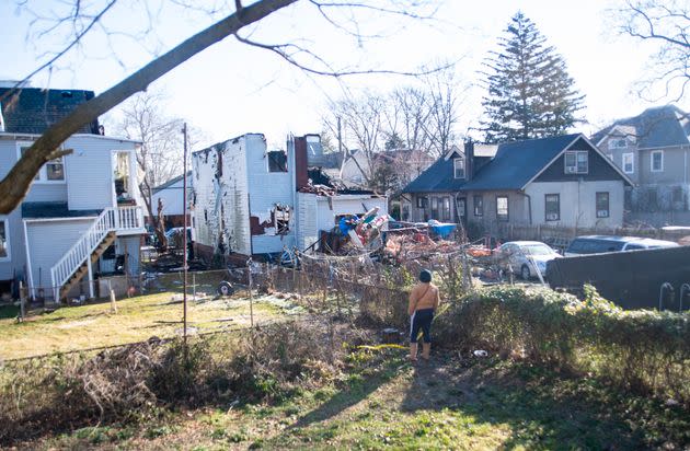 A neighbor inspects the remains of a home that was set ablaze and where at least six people remain unaccounted for on Thursday in East Lansdowne, Pennsylvania. 