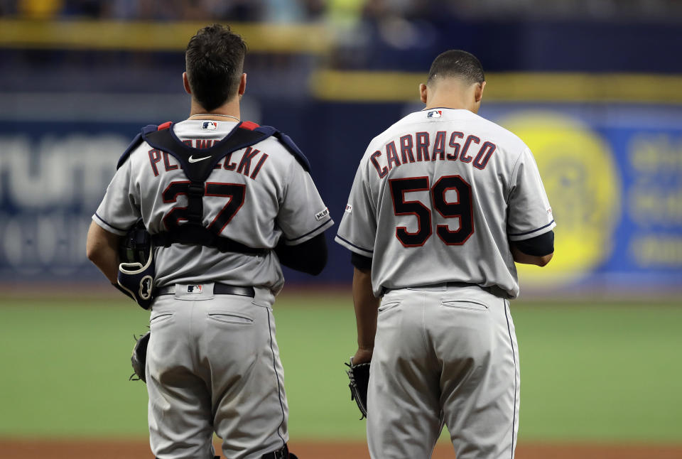 Cleveland Indians pitcher Carlos Carrasco (59) stands with catcher Kevin Plawecki during the playing of "God Bless America" in the seventh inning of a baseball game against the Tampa Bay Rays, Sunday, Sept. 1, 2019, in St. Petersburg, Fla. Carrasco is making his first appearance since May, when he was diagnosed with leukemia. (AP Photo/Chris O'Meara)