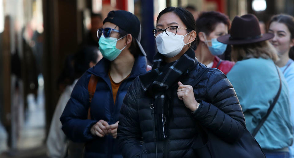 People walking through Melbourne CBD wearing face masks. 