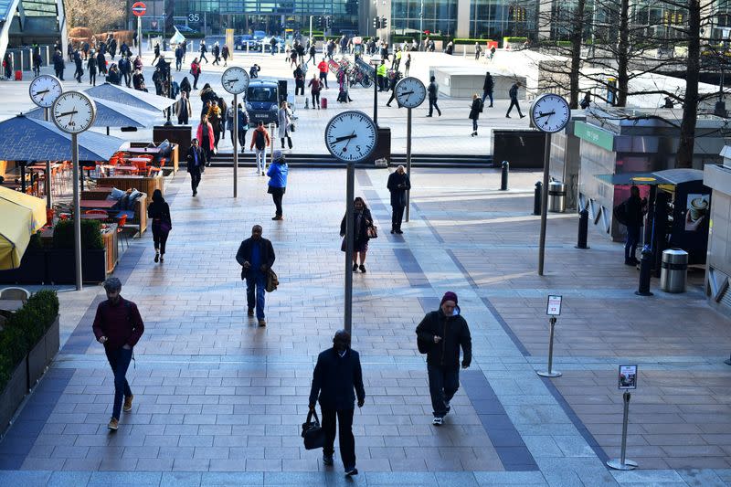 Commuters walk through Canary Wharf in London