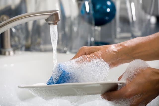 <p>Getty</p> Stock image of person doing dishes